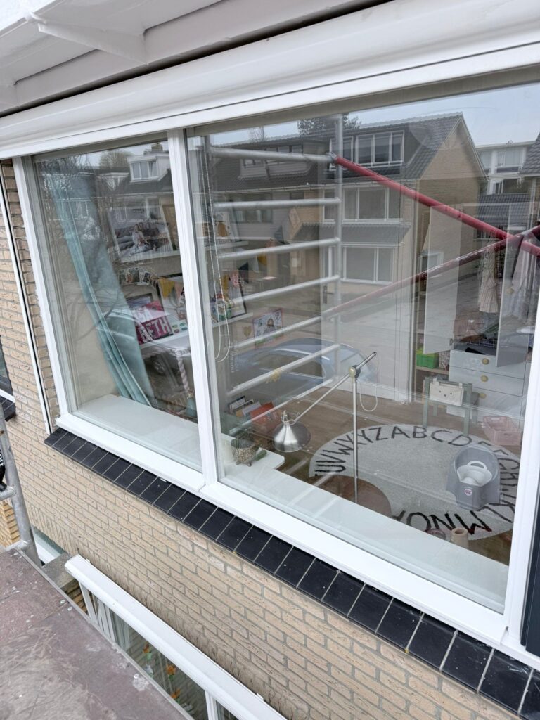 Uitzicht door raam naar binnenruimte met decoratie.