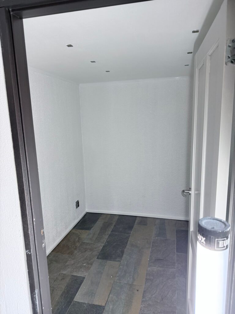 Lege kamer met donkere tegelvloer