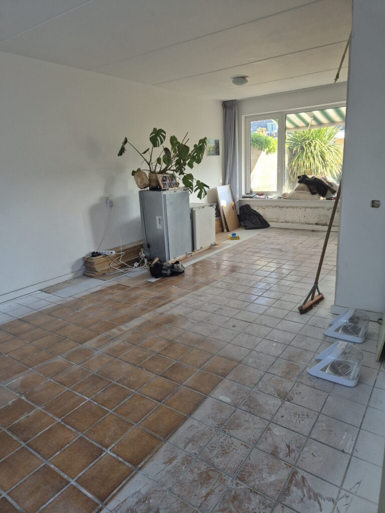 Woonkamer met kale tegelvloer en gereedschap