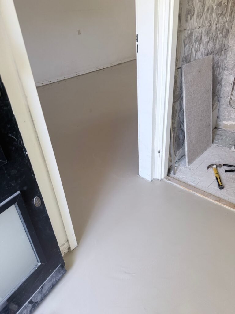 Nieuwe vloer in kamer met gereedschap opzij.