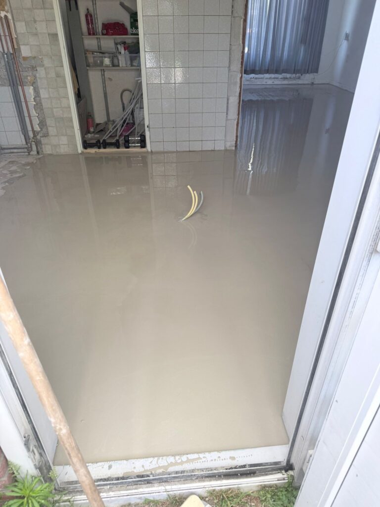 Vloer in aanbouw met nog natte cementdekvloer.