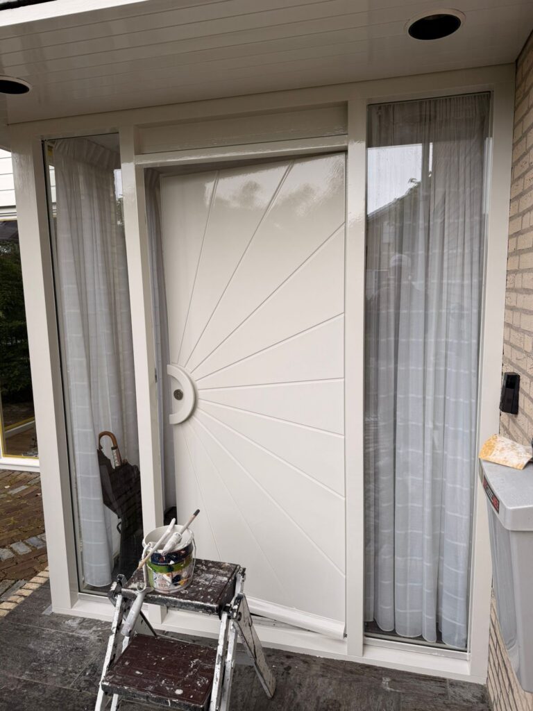 Wit geschilderde kozijnen en voordeur na buitenschilderwerk en houtrotreparatie aan een woning in Egmond-Binnen