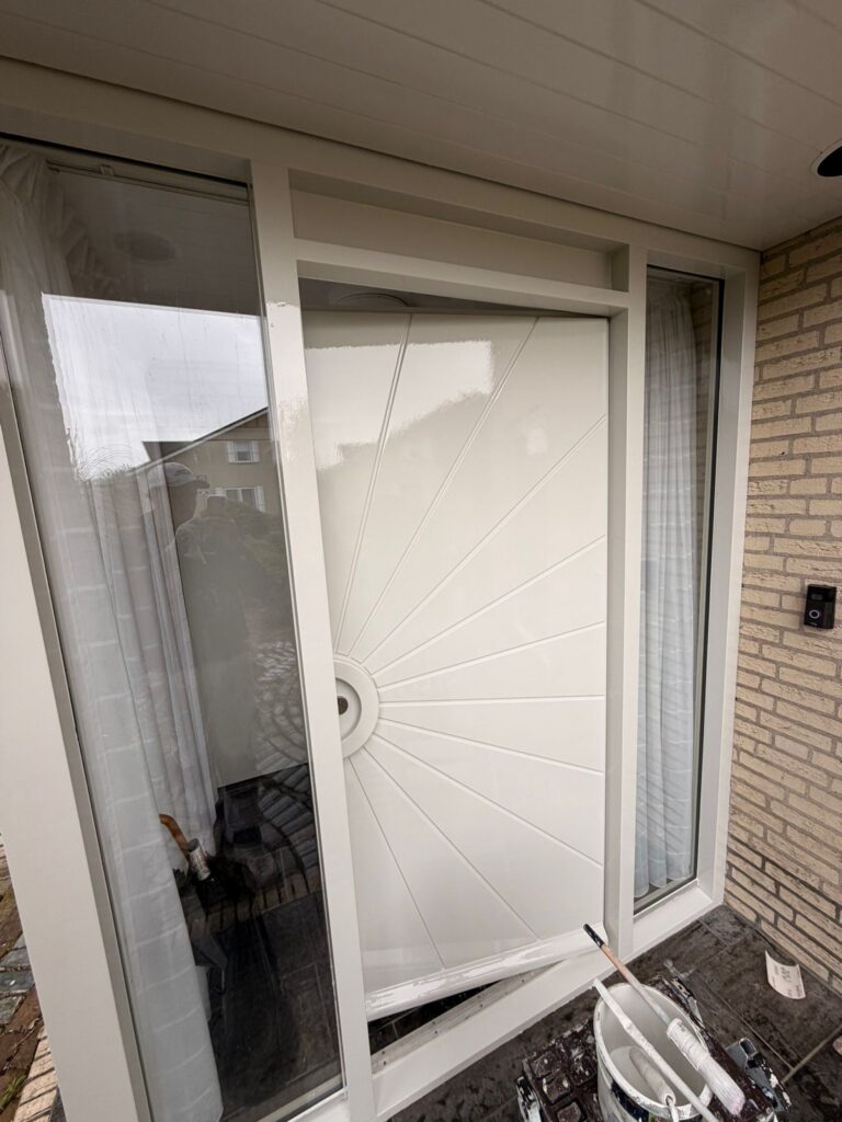 Wit geschilderde kozijnen en voordeur na buitenschilderwerk en houtrotreparatie aan een woning in Egmond-Binnen